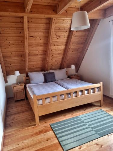 BurgebrachFerienwohnung Metzner Harnsbach的卧室配有木制天花板上的床铺