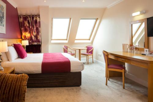 丁格尔西恩西比尔酒店的配有一张床和一张书桌的酒店客房