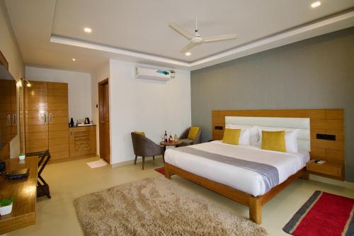 莫尔吉姆FabHotel Resort De Ashvem的一间卧室配有一张床、一张桌子和一张桌子