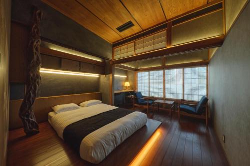 熊本Tudzura的一间卧室配有一张床、一张书桌和一个窗户。