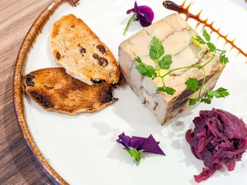 巴黎巴黎中心埃菲尔铁塔之旅诺富特酒店的一块食物,有肉,面包和紫色的鲜花