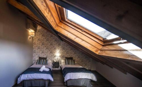 莫利纳塞卡Rustik Hostal Rural的阁楼间设有两张床和天窗