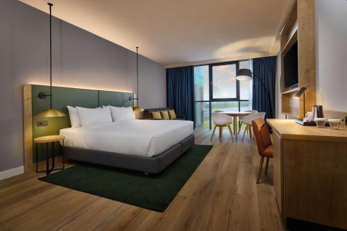 莱顿莱顿希尔顿花园酒店的酒店客房设有一张大床和一张书桌。