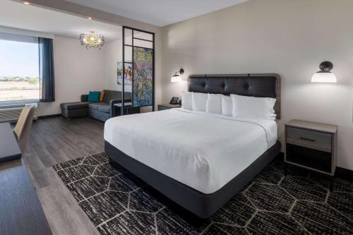 MaricopaLa Quinta Inn & Suites by Wyndham Maricopa Copper Sky的一间带大床的卧室和一间客厅