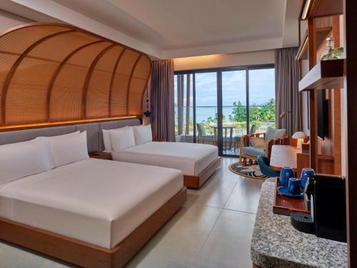 Anse a La MoucheCanopy By Hilton Seychelles Resort的酒店客房配有两张床和一张书桌