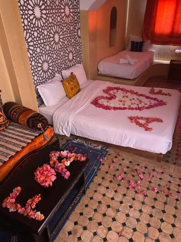 达赫拉Dar Rio Oro的一间设有两张床的客房,地板上鲜花盛开