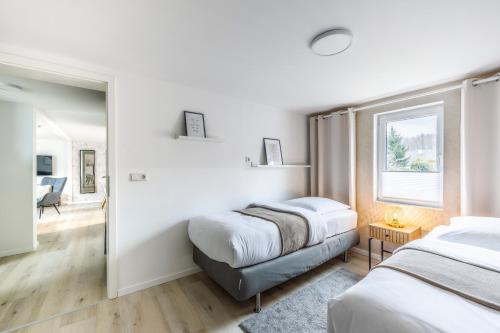 约阿希姆斯塔尔Großes Ferienhaus 70 QM mit 2 Schlafzimmer I 5 min zum See I überdachte Terrasse I nahe Werbellinsee的一间卧室设有两张床和窗户。