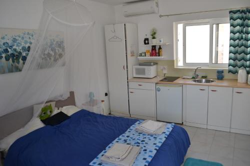 姆西达SeaBreeze penthouse close to Sliema and Valletta的一间带蓝色床的卧室和一间厨房