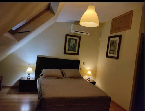 马德里apartamento noviembre的卧室配有一张床,墙上有两盏灯