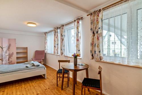 卡尔夫Zentral und nett in Calw的一间卧室配有一张床、一张桌子和一个窗户。