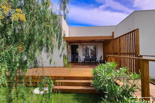 维亚斯Villa T3 climatisée en résidence avec piscine的度假屋设有木制平台和天井。