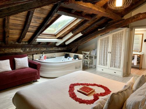 LastrasAkla Hotel Palacio Torre de Ruesga的一间带浴缸的卧室和一张带蛋糕的床