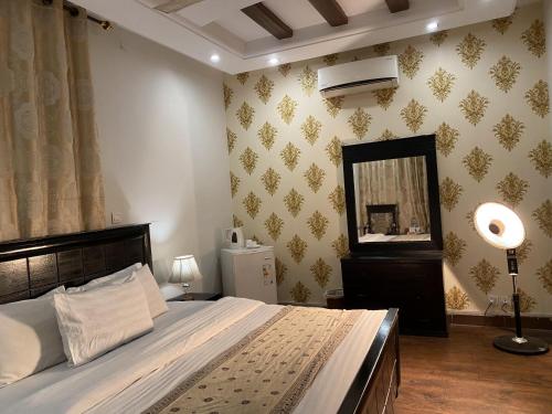 伊斯兰堡Harvey's Islamabad的一间卧室配有一张大床和镜子