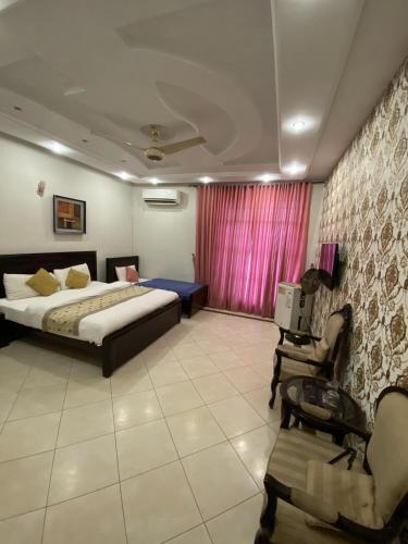 伊斯兰堡Harvey's Islamabad的一间卧室配有一张床、一张桌子和一把椅子