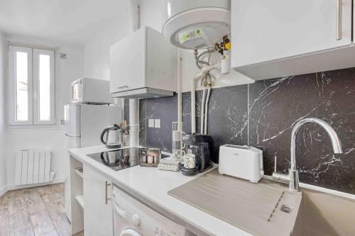 马拉科夫Appartement chic proche gare de Clamart + Netflix的厨房配有白色橱柜和台面