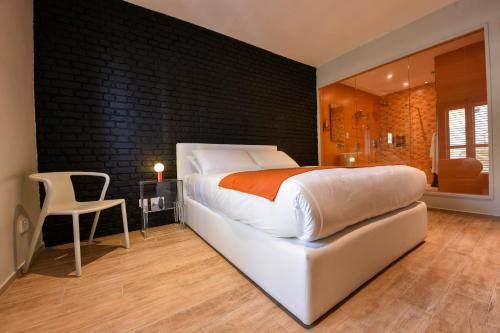 萨奈特Quaint Boutique Hotel Sannat的卧室配有白色的床和黑色墙壁
