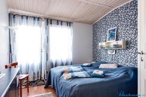 奥卢图卢森萨哈旅馆的一间卧室配有蓝色的床,拥有蓝色和白色的壁纸
