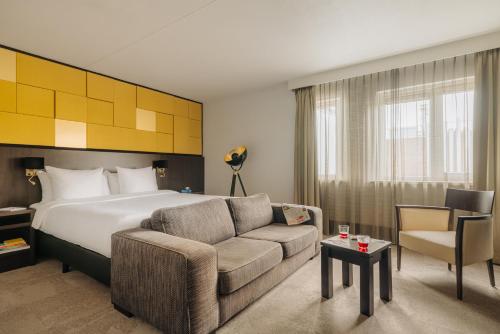 吕伐登Oranje Hotel Leeuwarden的酒店客房,配有床和沙发