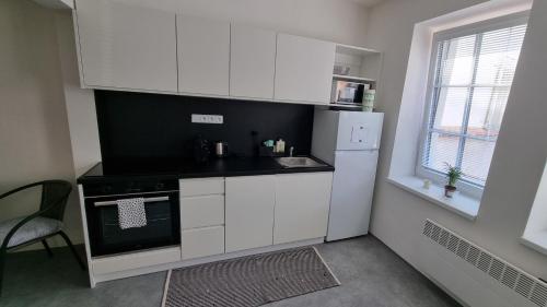 利托梅日采Apartmány Atrium的小厨房配有白色橱柜和黑炉