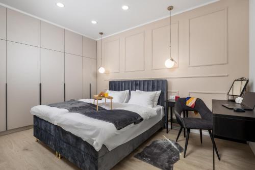 里耶卡Area Luxury Spa Apartment的一间卧室配有一张床、一张桌子和一把椅子