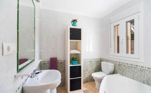 诺沃桑克蒂佩特里Chalet en la Barrosa的白色的浴室设有水槽和卫生间。