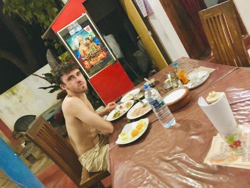 蒂瑟默哈拉默Tashil Hotel & Restaurant的坐在餐桌上吃一盘食物的人
