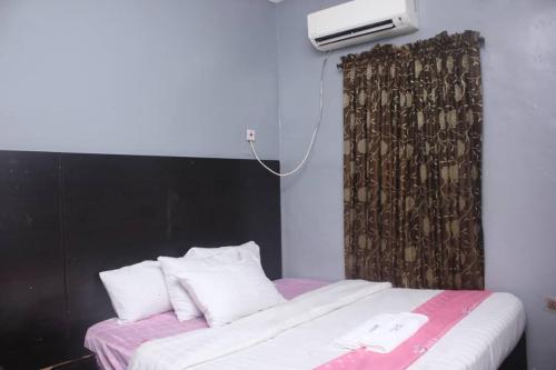 莱基D’ ISLAND AND CLUB HOTEL的一间卧室配有一张带黑色床头板和白色枕头的床。