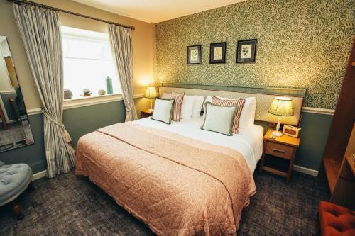 贝克韦尔The Ashford Arms的一间卧室设有一张大床和一个窗户。