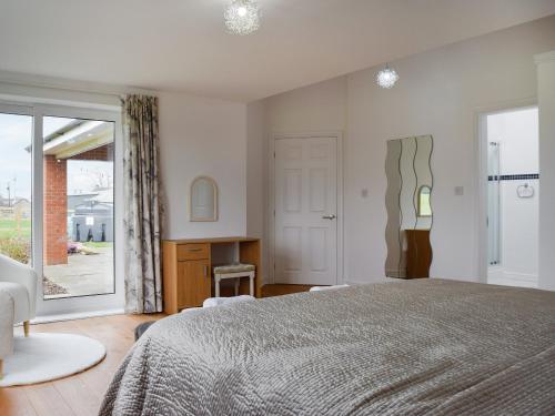 文斯福The Crofts的一间卧室配有一张床、一张书桌和一个窗户。