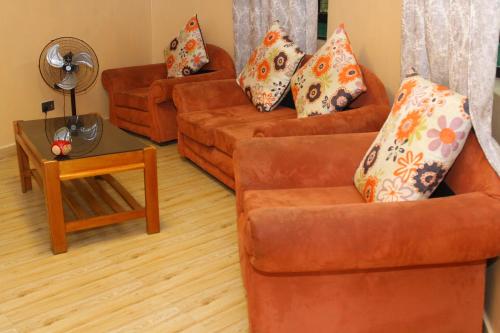 NarokBanana Hills Haven的客厅配有2张橙色沙发和1张桌子