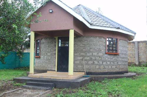 NarokBanana Hills Haven的一座小房子,设有门廊和黄色柱子