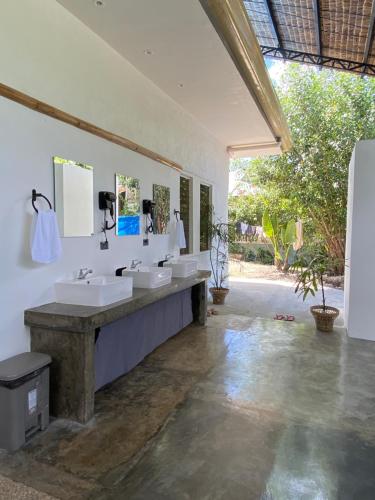 莫阿尔博阿Wild Monkeys Hostel的一间带三个水槽和大镜子的浴室