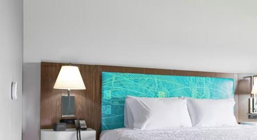 芝加哥Hampton Inn & Suites Chicago Medical District Uic的一间卧室配有一张大床和蓝色床头板