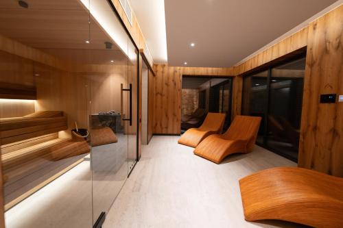 什切尔克Apartamenty Pod Gondolą - Mountain Resort Villa z sauną - Dream Apart的一间设有木墙、椅子和玻璃墙的客房