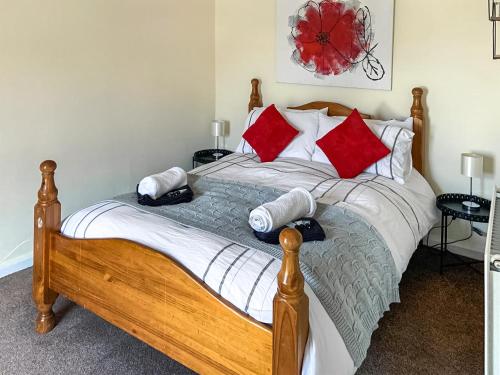 库姆马丁Roseus - Uk44706的一间卧室配有红色和白色枕头的床