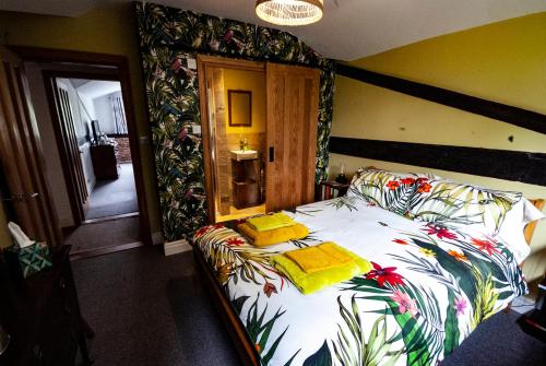 ThursleyHigh Barn的一间卧室配有一张带花卉床罩的大床