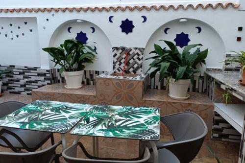 格拉纳达Casa preciosa con vistas的庭院配有桌椅和植物