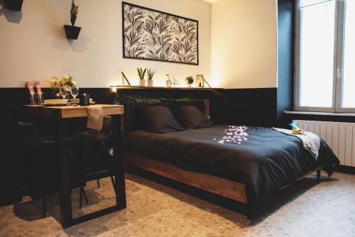 昂热LOVE ROOM, La Douce Angevine的一间卧室配有一张床、一张桌子、一张桌子和一张四柱床。