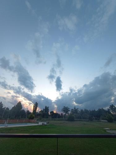 乌拉圭河畔康塞普西翁Ndori Bungalows的公园里棕榈树云 ⁇ 的天空