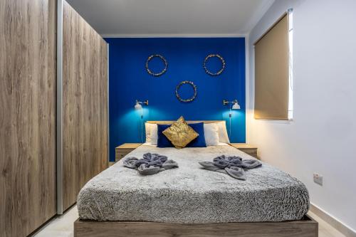 San ĠwannTa Cetta Apartment 5 min walk from St Julians的一间卧室配有一张带蓝色墙壁的大床
