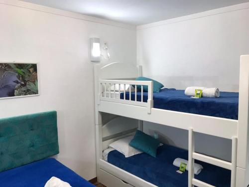 格拉玛多Hospedagem Vida e Natureza的一间卧室配有两张双层床,铺有蓝色床单。