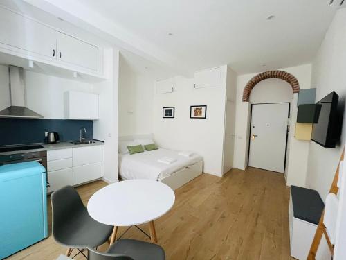 米兰Lomat Apartment的一间白色的厨房,配有白色的桌子和房间