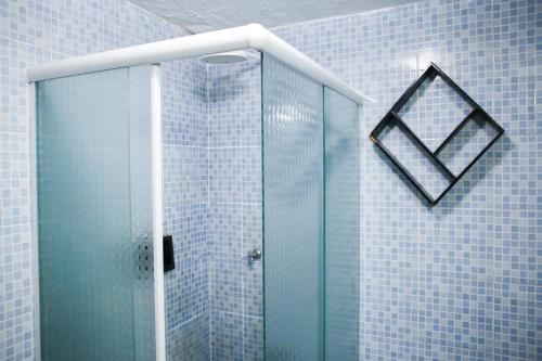 圣塔伦Barrudada Santarém的浴室设有玻璃淋浴间,铺有蓝色瓷砖