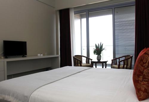 BenguelaFlow Hotel Benguela的卧室配有一张白色大床和电视。