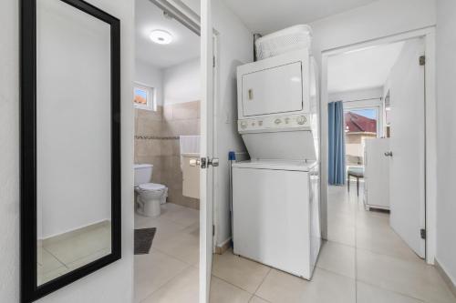棕榈滩Adele's Apartment with Pool, 5 minutes walk to the beach的浴室设有白色冰箱和镜子