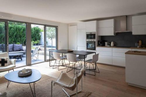 克雷泰伊Maison d'architecte - Piscine的厨房以及带桌椅的起居室。