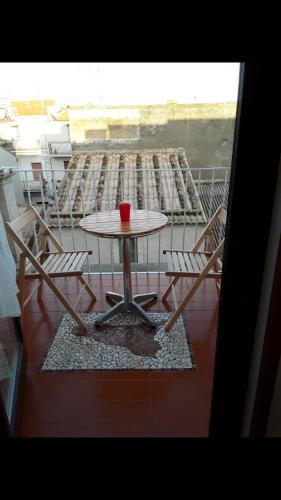 AcateDa zia Franca的阳台上的桌子和椅子上放着红杯