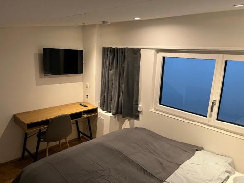 圣珀尔滕Business City Lodge的一间卧室配有一张床、一张书桌和一个窗户。