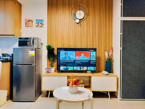 马尼拉Shell Residences by Amonbrey Suite nr airport的厨房配有冰箱和电视桌。