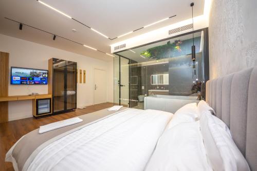 地拉那Hotel Riviera的一间卧室配有一张大床和电视